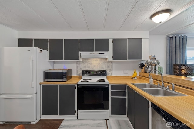 kitchen featuring a sink, appliances with stainless steel finishes, under cabinet range hood, and light countertops