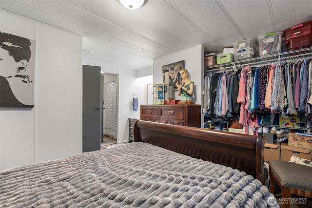 bedroom with a decorative wall, a closet, and a textured ceiling