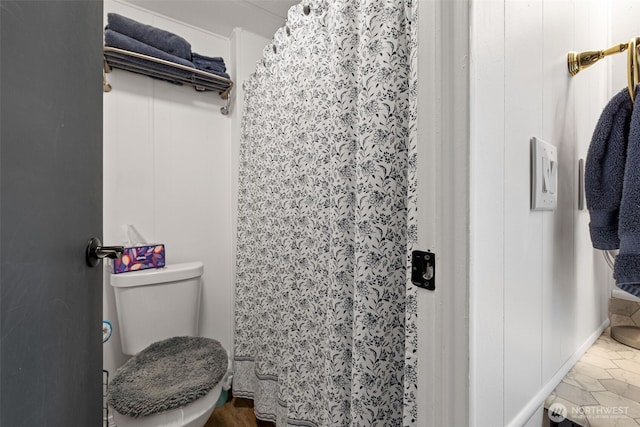 bathroom featuring toilet and a shower with curtain