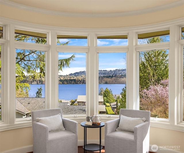 sunroom / solarium featuring baseboards, a water view, and crown molding