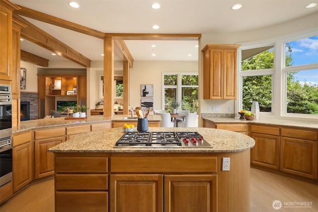 kitchen featuring a fireplace, recessed lighting, appliances with stainless steel finishes, and a kitchen island