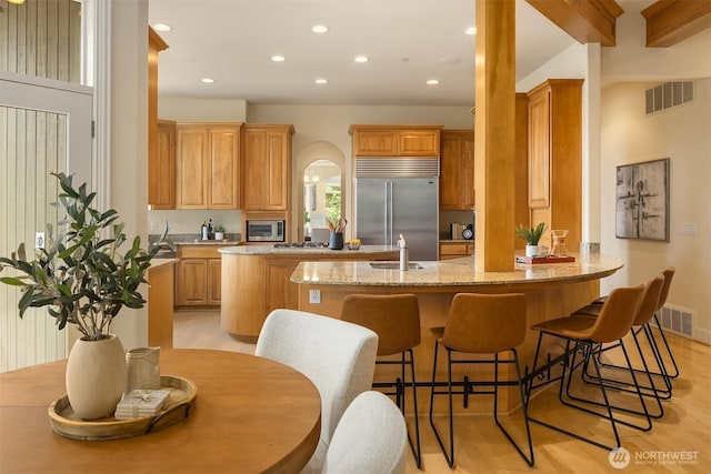 kitchen featuring recessed lighting, a sink, stainless steel appliances, visible vents, and a peninsula