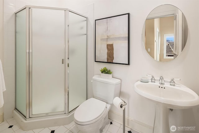 full bath featuring toilet, tile patterned flooring, a stall shower, and a sink