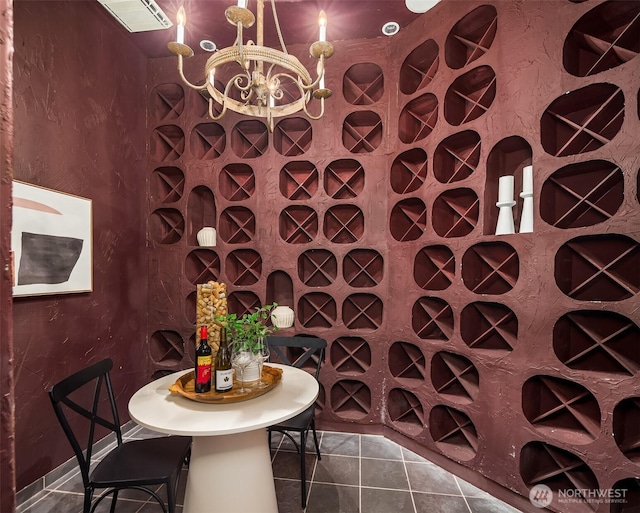 wine room with tile patterned flooring and an inviting chandelier