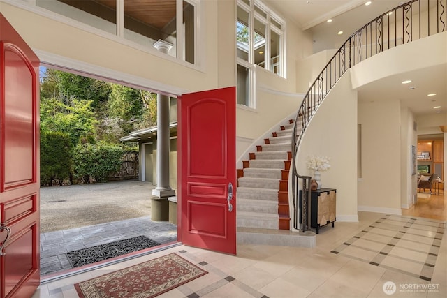 foyer entrance with a high ceiling, recessed lighting, tile patterned flooring, and stairway