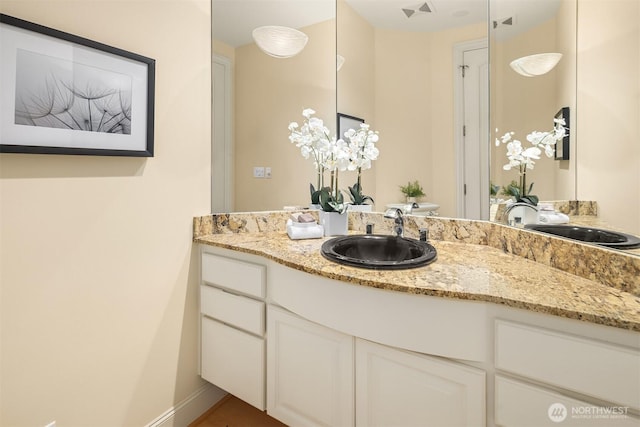 bathroom with toilet, visible vents, vanity, and baseboards