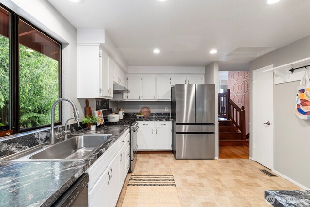 kitchen featuring dark countertops, recessed lighting, a sink, a wealth of natural light, and stainless steel appliances