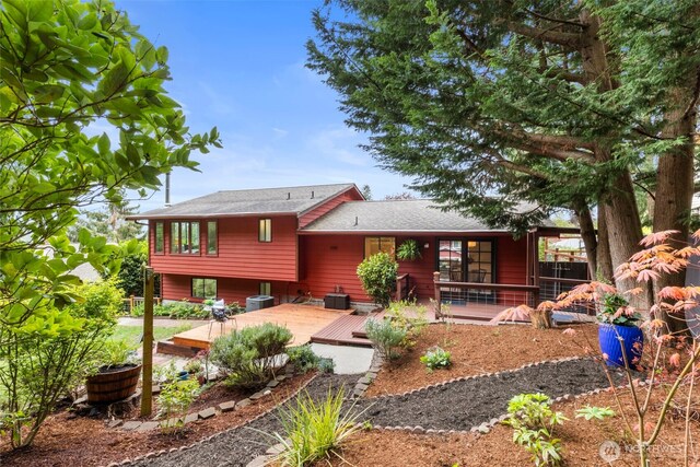 rear view of property with roof with shingles and central AC