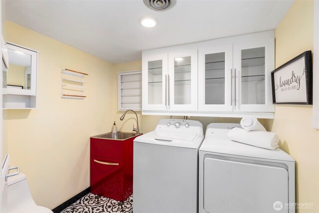laundry room with cabinet space, a sink, baseboards, recessed lighting, and washer and clothes dryer