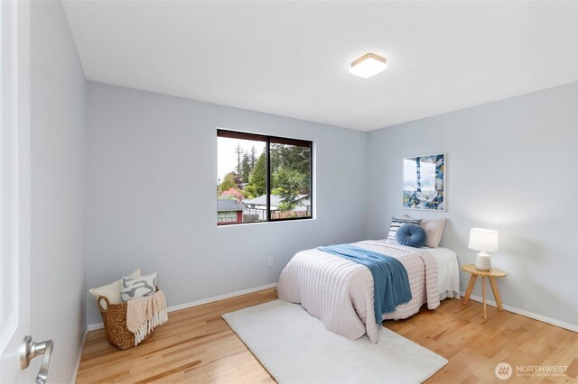 bedroom with baseboards and wood finished floors