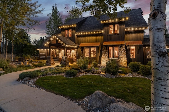 8105 Icicle Rd, Leavenworth, WA 98826 - view of front of house featuring a front lawn, board and batten siding, roof with shingles, and stone siding