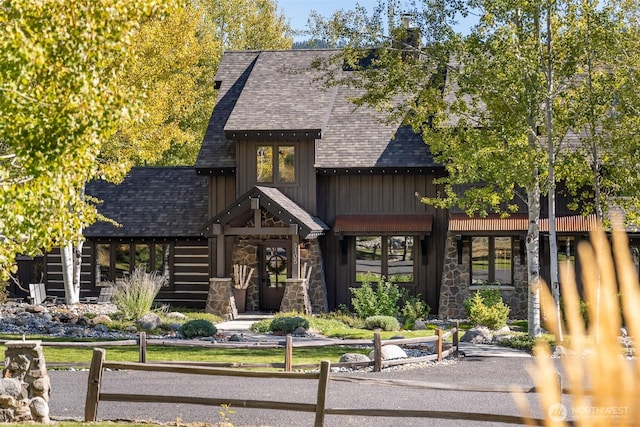 8105 Icicle Rd, Leavenworth, WA 98826 - view of front of property with fence, a shingled roof, stone siding, and board and batten siding
