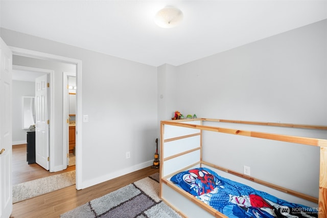 bedroom featuring baseboards and wood finished floors