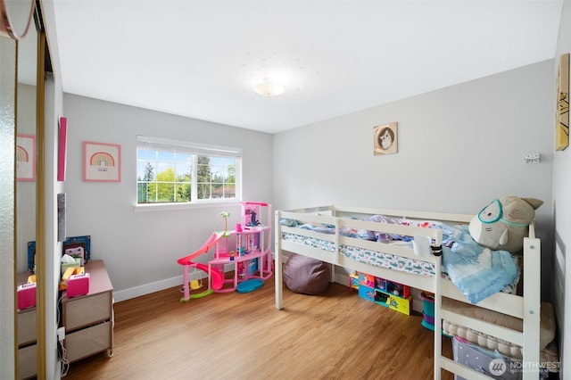 bedroom featuring baseboards and wood finished floors
