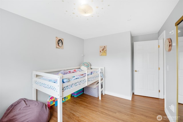bedroom featuring baseboards and wood finished floors
