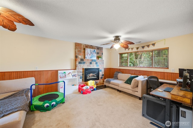 living room featuring a wainscoted wall, ceiling fan, carpet flooring, and wood walls