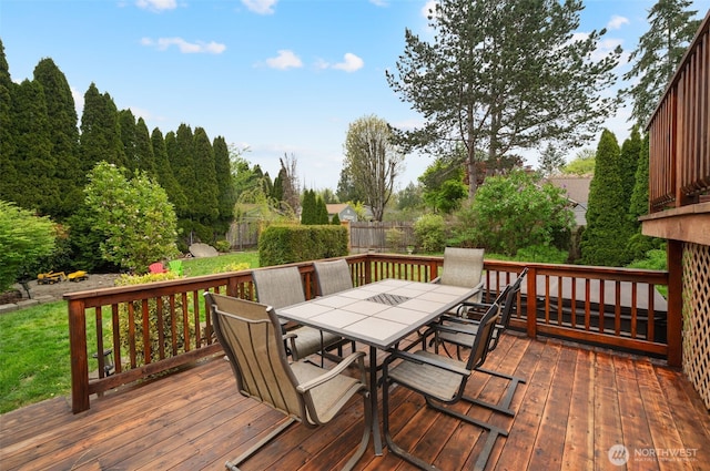 wooden terrace with a fenced backyard and outdoor dining space
