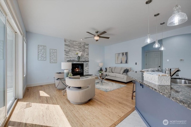 1447 Everette Ln, Freeland, WA 98249 - living area featuring visible vents, a fireplace, baseboards, a ceiling fan, and light wood finished floors