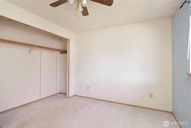 unfurnished bedroom featuring a closet, ceiling fan, light colored carpet, and baseboards