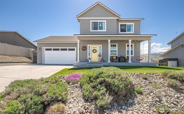 traditional home featuring a garage, fence, covered porch, and driveway