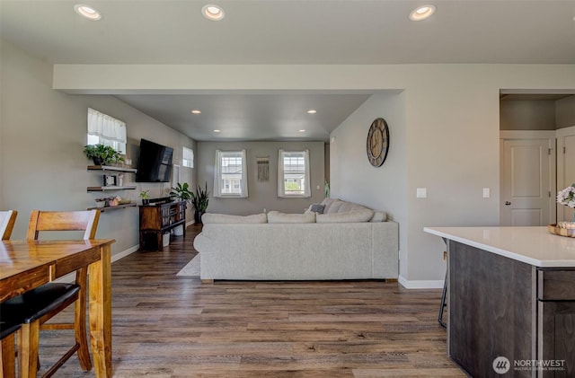 living area featuring recessed lighting, baseboards, and dark wood finished floors