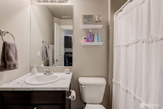 full bath featuring vanity, a shower with curtain, toilet, and visible vents