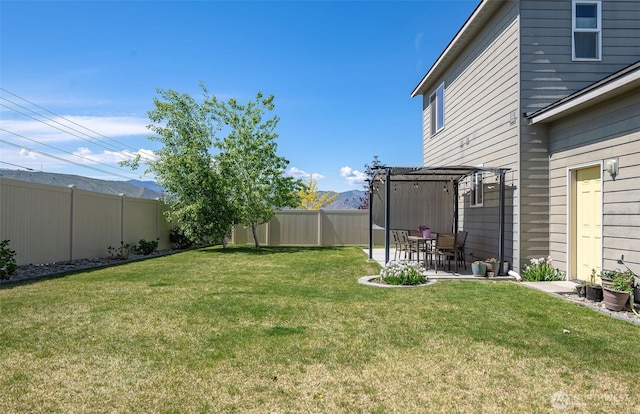 view of yard featuring a fenced backyard, a patio area, a mountain view, and a pergola