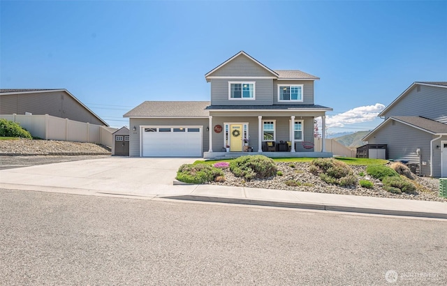 view of front of home with fence, an attached garage, concrete driveway, and a porch