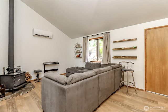 17936 Clearland Blvd SE, Yelm, WA 98597 - living room featuring a wall mounted air conditioner, a wood stove, vaulted ceiling, and light wood-style flooring