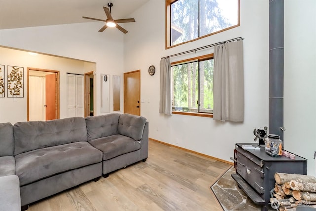 17936 Clearland Blvd SE, Yelm, WA 98597 - living area featuring a wood stove, ceiling fan, high vaulted ceiling, baseboards, and wood finished floors