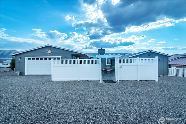 exterior space with a garage, fence, driveway, and a chimney