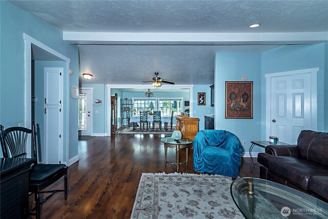 living room featuring baseboards, ceiling fan, and wood finished floors