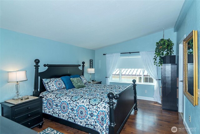 bedroom with baseboards, dark wood finished floors, and lofted ceiling