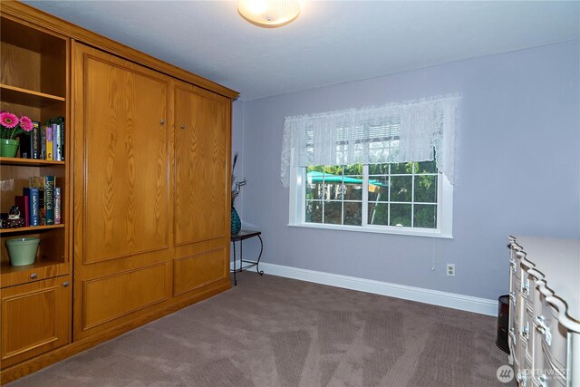 bedroom featuring baseboards and dark colored carpet