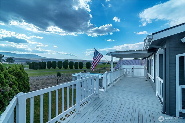 wooden deck featuring a mountain view and a yard