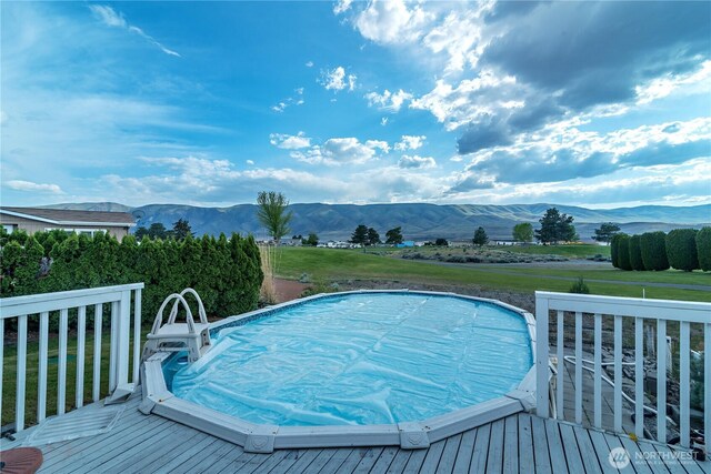 view of pool featuring a hot tub and a deck with mountain view