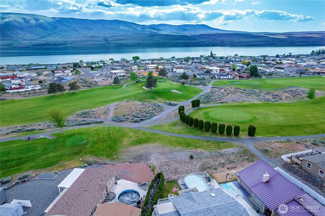 drone / aerial view with a residential view, a water and mountain view, and golf course view