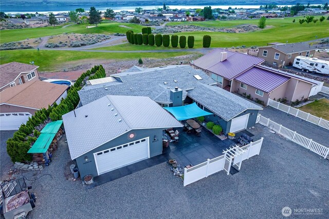 drone / aerial view with view of golf course and a water view