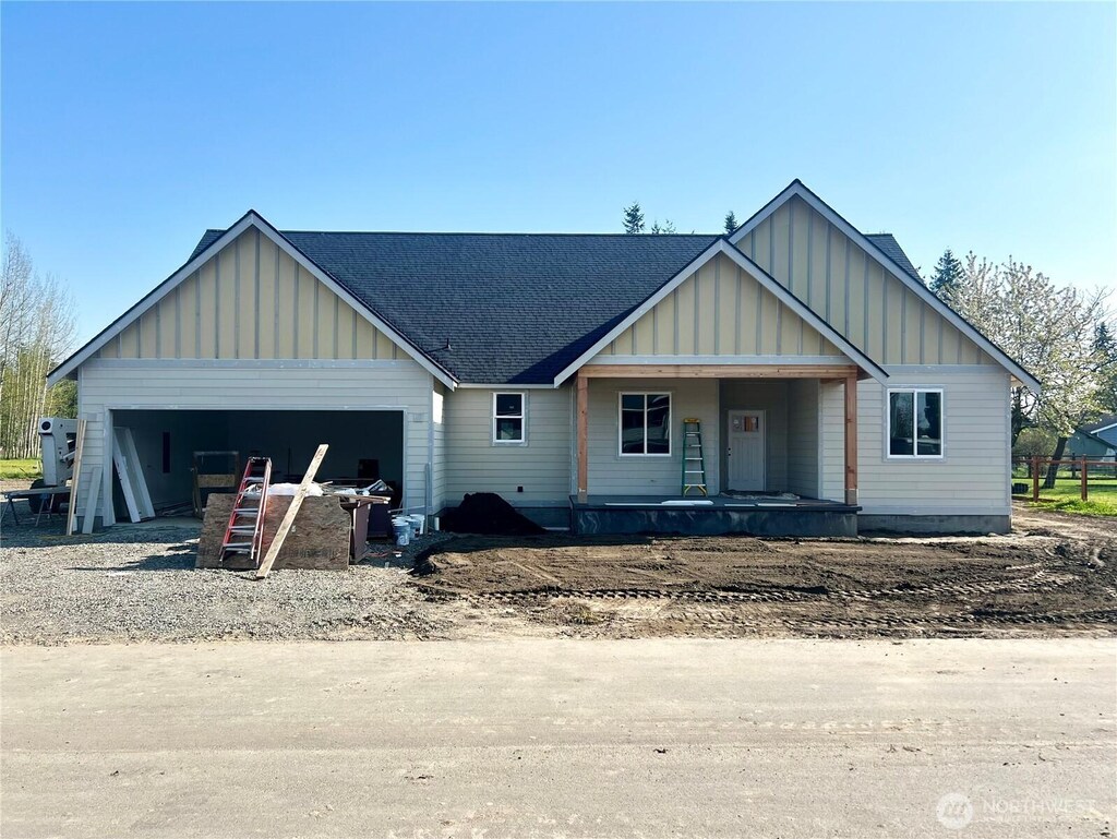 view of front of property featuring board and batten siding, a porch, driveway, roof with shingles, and an attached garage