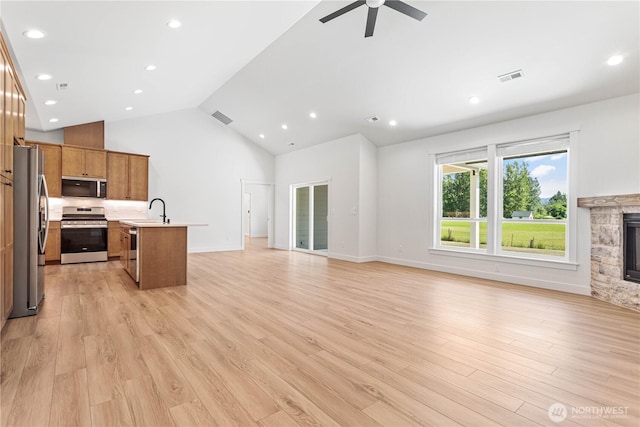1200 E Georgia Ln, Everson, WA 98247 - unfurnished living room with ceiling fan, a stone fireplace, light wood-style floors, high vaulted ceiling, and recessed lighting