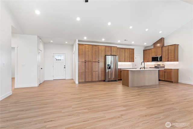1200 E Georgia Ln, Everson, WA 98247 - kitchen featuring stainless steel appliances, a center island with sink, light wood-type flooring, light countertops, and brown cabinetry