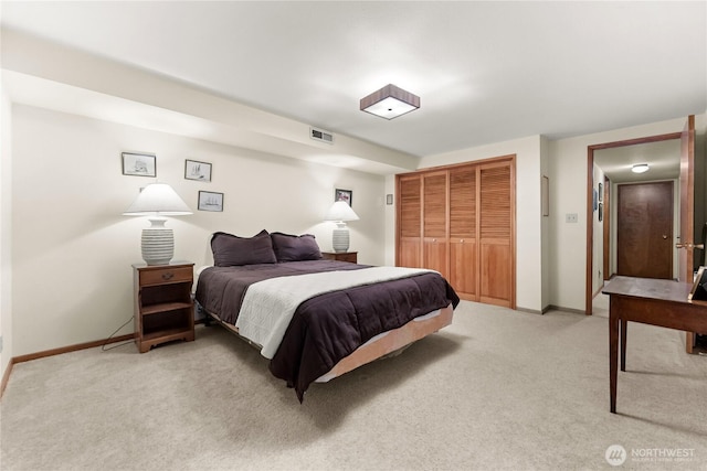 bedroom with baseboards, visible vents, a closet, and light colored carpet