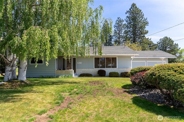 ranch-style house featuring a garage, a shingled roof, and a front yard