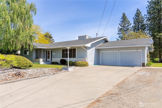 ranch-style house featuring an attached garage, driveway, and a chimney