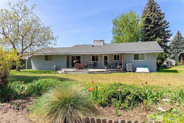 rear view of property featuring a yard, central AC, a chimney, and a patio area