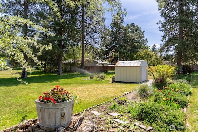 view of yard featuring a storage shed, fence, and an outbuilding