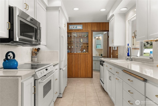 kitchen featuring light countertops, white cabinetry, tasteful backsplash, a sink, and stainless steel appliances