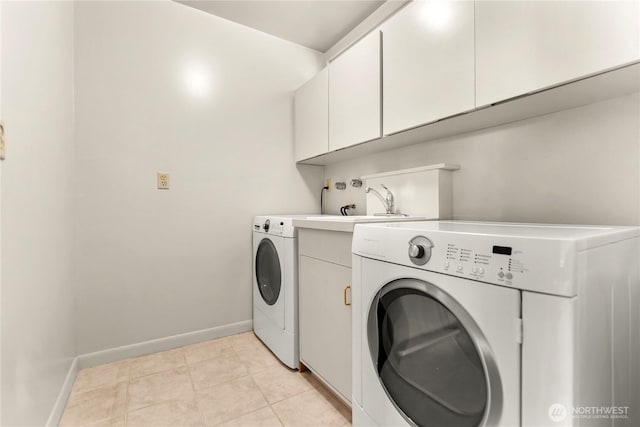 laundry area featuring baseboards, washing machine and dryer, and cabinet space