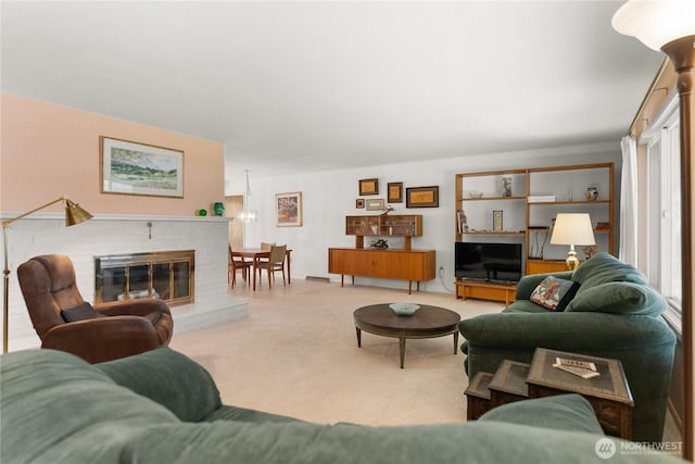 living area featuring carpet and a brick fireplace