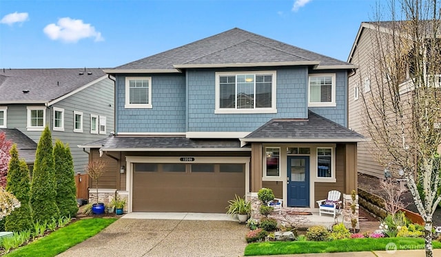 view of front facade with concrete driveway, a shingled roof, and a garage